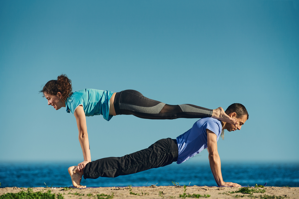 Pair sporty yoga women doing exercise on gray stylish background. Couple  yoga pose. Stock Photo | Adobe Stock